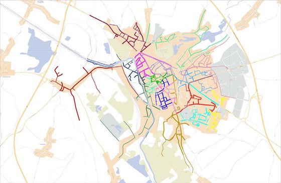 Postal delivery routes drawn in color over the street map of a French town.